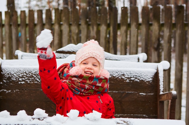 Linda garota brincalhona ao ar livre curtindo a primeira neve.