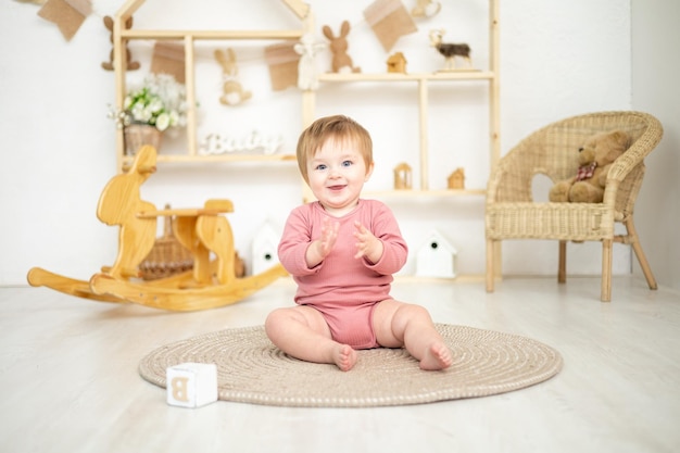 Linda garota brincando com brinquedos naturais de madeira no quarto das crianças em casa brinquedos educativos para o interior do quarto das crianças