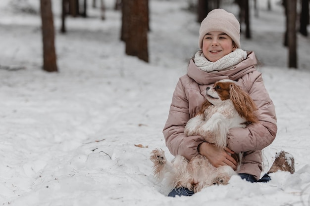 Linda garota brincando com cachorro na floresta de winter park