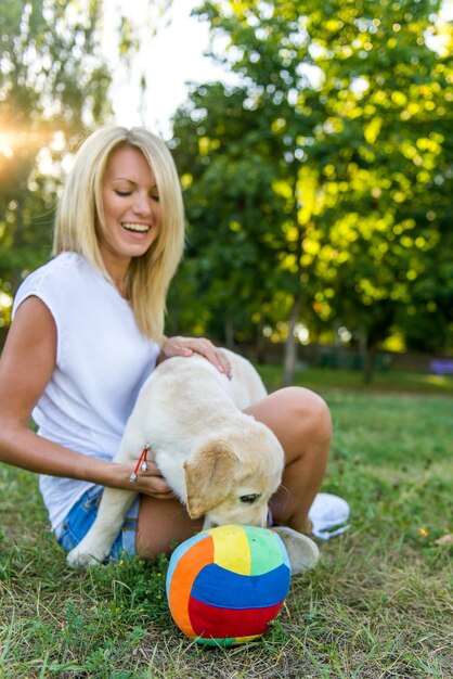 Linda garota brincando com um cachorro labrador