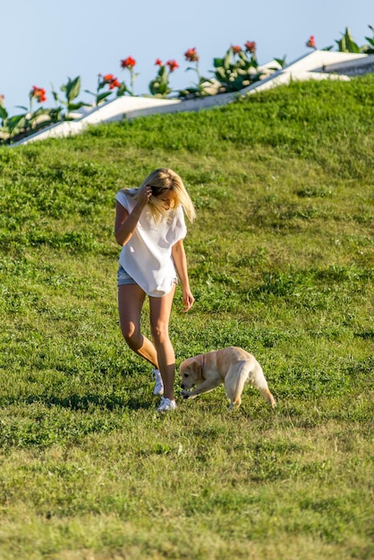 Linda garota brincando com um cachorro labrador