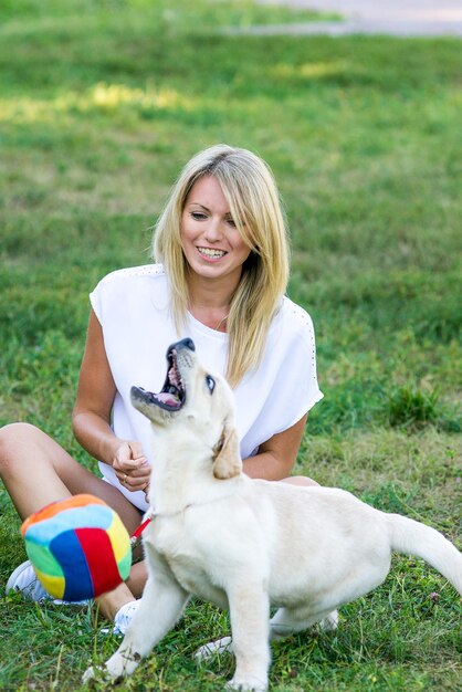 Linda garota brincando com um cachorro labrador