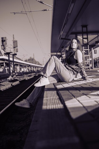 Foto linda garota caucasiana posando na plataforma ferroviária