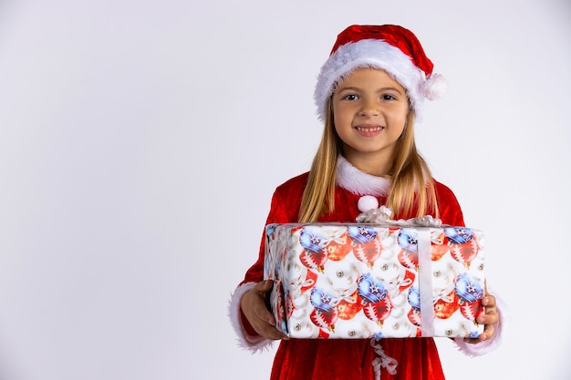 Linda garota caucasiana sorridente com chapéu de papai noel vermelho e fantasia segurando o presente de natal