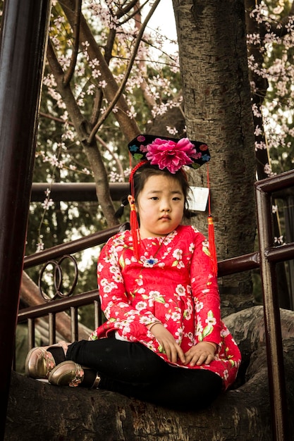 Linda garota chinesa posando para a câmera vestindo roupas tradicionais, China