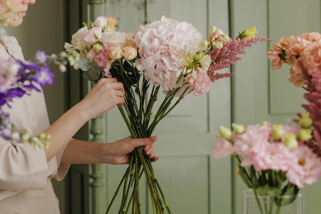 Linda garota coleta um buquê de flores em uma loja de flores