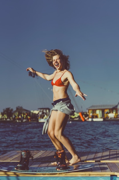 linda garota com cabelo comprido com um wakeboard