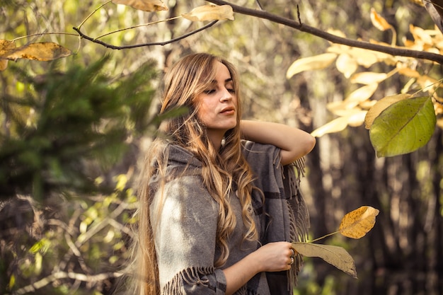 linda garota com cabelo comprido na floresta de outono, conceito de temporada de outono