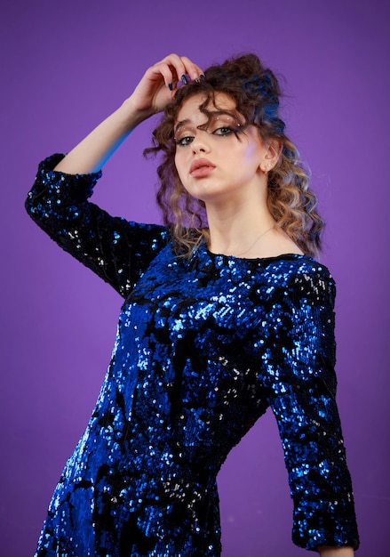 Linda garota com cabelo encaracolado em fundo roxo Foto de alta qualidade