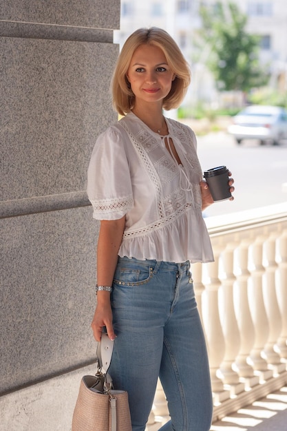 Foto linda garota com café nas mãos em estilo urbano