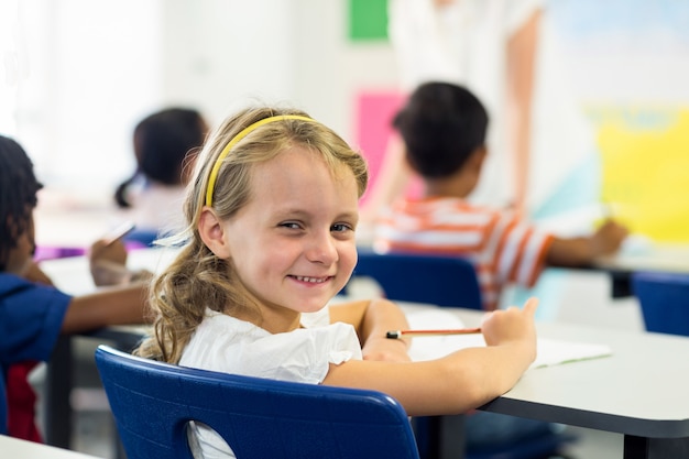 Linda garota com colegas em sala de aula