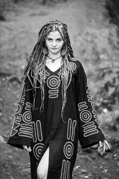 Linda garota com dreadlocks vestidos de estilo hippie ao ar livre