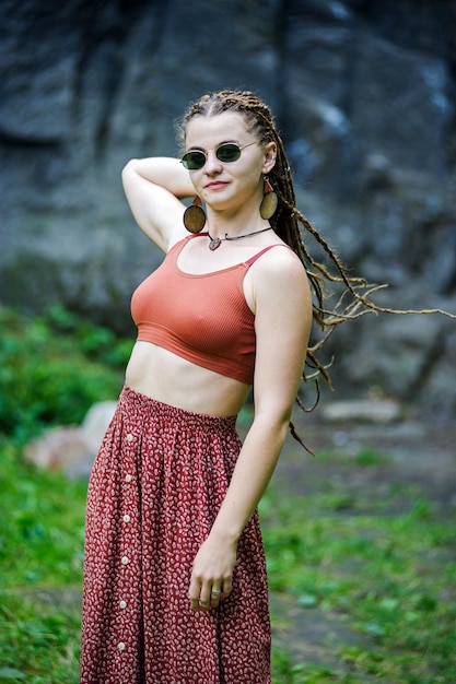 Linda garota com dreadlocks vestidos de estilo hippie ao ar livre