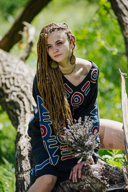 Linda garota com dreadlocks vestidos de estilo hippie ao ar livre