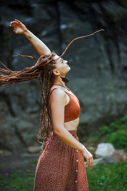 Linda garota com dreadlocks vestidos de estilo hippie ao ar livre