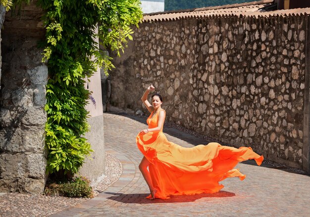 Linda garota com incrível vestido laranja esvoaçante