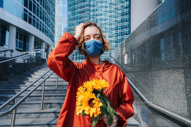 Linda garota com máscara protetora de rosto Cabelo esvoaçando Momento sensual Moda urbana Retrato de mulher ao ar livre Conceito natureza na cidade urbana sem máscaras cancelamento de uso de máscara