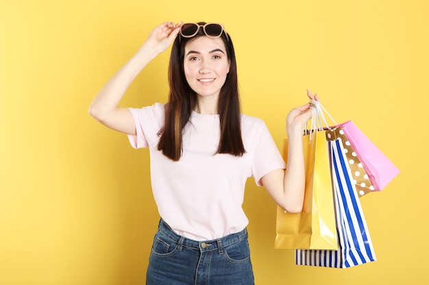 Linda garota com sacos de papel para fazer compras