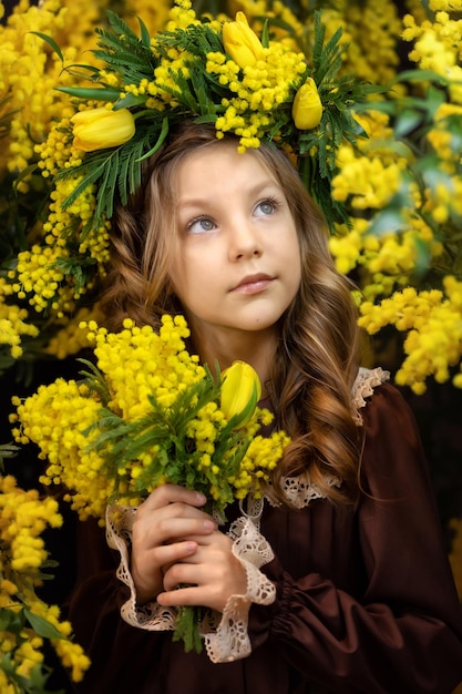 Linda garota com um buquê de flores de mimosa