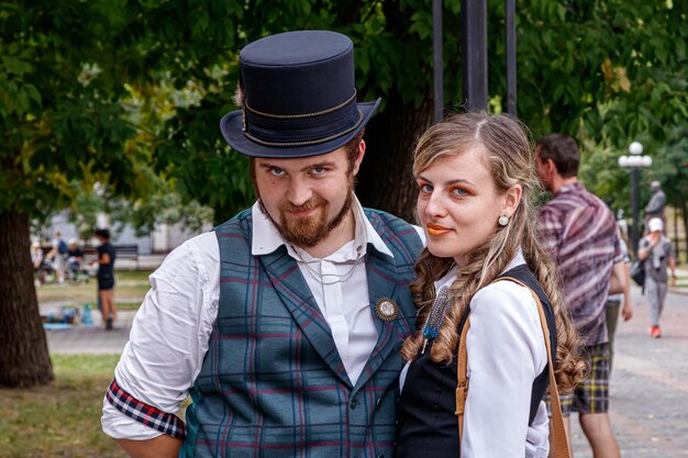 Linda garota com um casal de caras apaixonados em roupas steampunk