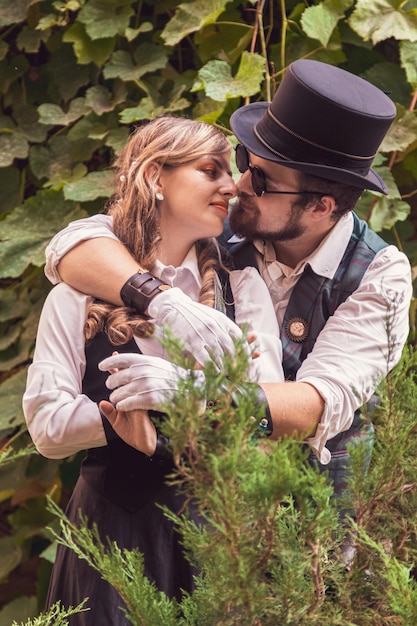 Linda garota com um casal de caras apaixonados em roupas steampunk