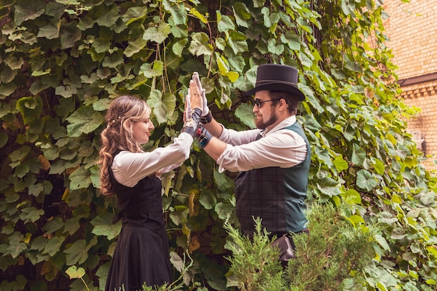 Linda garota com um casal de caras apaixonados em roupas steampunk