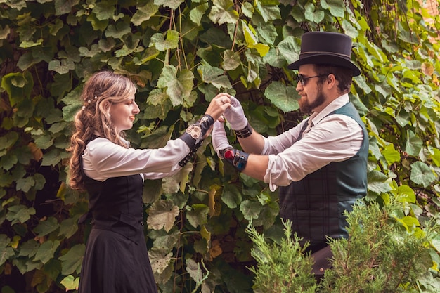 Linda garota com um casal de caras apaixonados em roupas steampunk