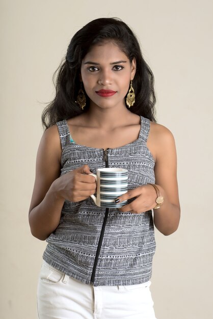 Linda garota com uma xícara de chá ou café posando