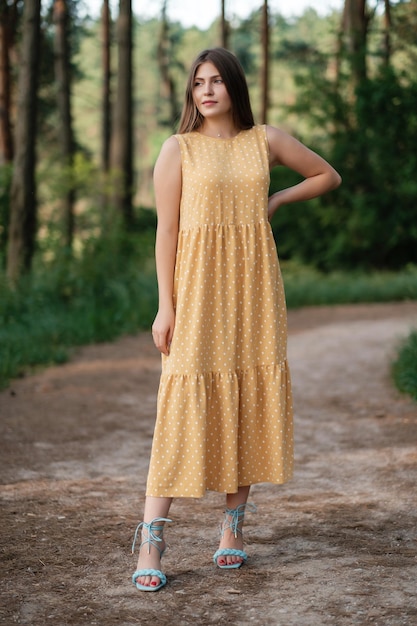 Linda garota com vestido amarelo de verão ao ar livre