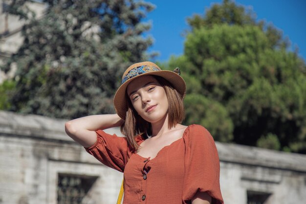 Linda garota com vestido laranja posando na praça Suleymaniye