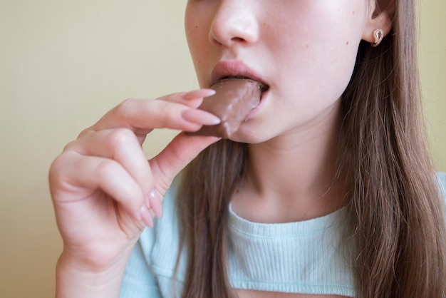 Linda garota comendo chocolate closeup