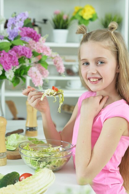 Linda garota comendo deliciosa salada fresca