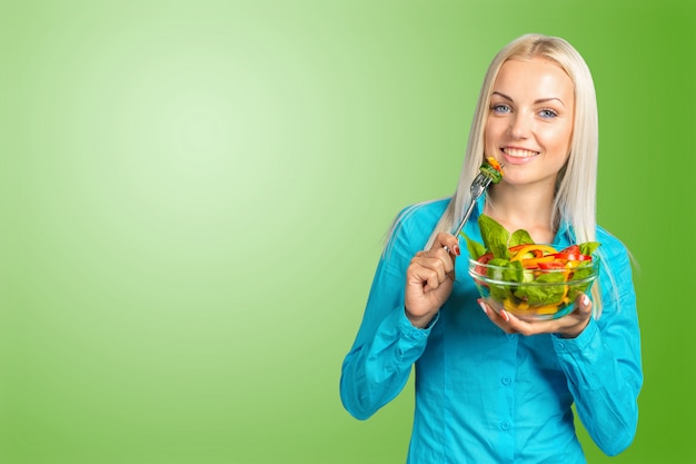 Linda garota comendo uma salada