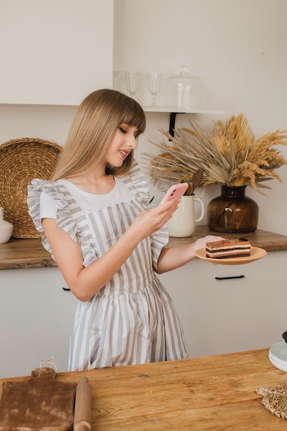 Linda garota confeiteira ou dona de casa fotografando sobremesa por telefone