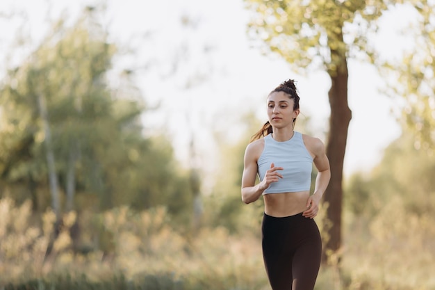 Foto linda garota corre no parque em uma camiseta esportiva executando saúde