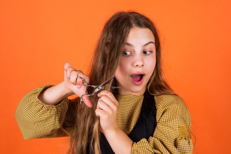 Foto linda garota cortando cabelo para si mesma com tesoura criança é aparada no cabeleireiro criança com tesoura quer cortar cabelo garota no salão de cabeleireiro adolescente cortando cabelo espere grandeza