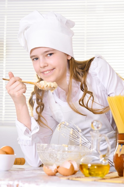 Linda garota cozinhando na cozinha em casa