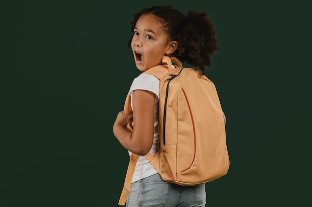 Linda garota da escola e sua mochila vista de trás