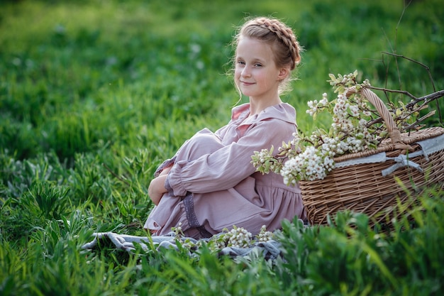 Linda garota de 6 a 7 anos de idade, posando no jardim. Páscoa. gosta de primavera e calor. Belo jardim de primavera. Conceito de infância, paz e felicidade feliz. Flor aromática e vintage retrô.