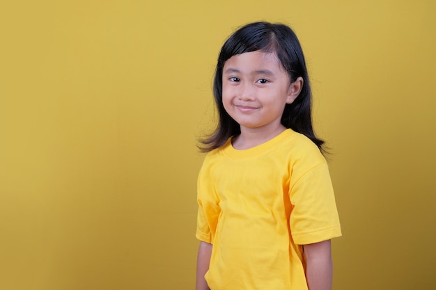 Linda garota de cabelo preto em camiseta amarela sorrindo