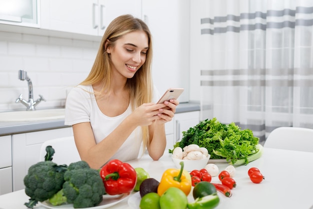 Linda garota de dieta usando smartphone para verificar a caloricidade