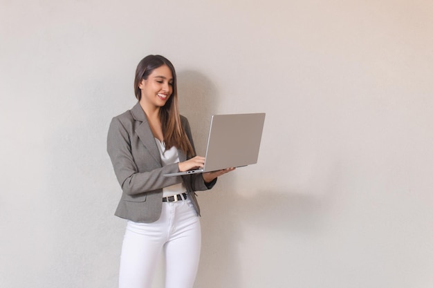 Linda garota de negócios usando laptop em fundo branco