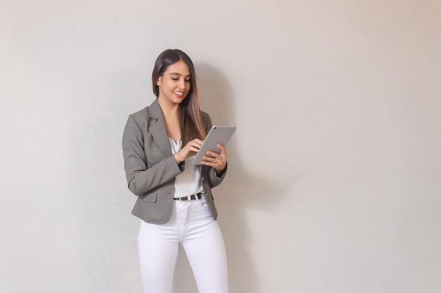 Linda garota de negócios usando tablet em fundo branco