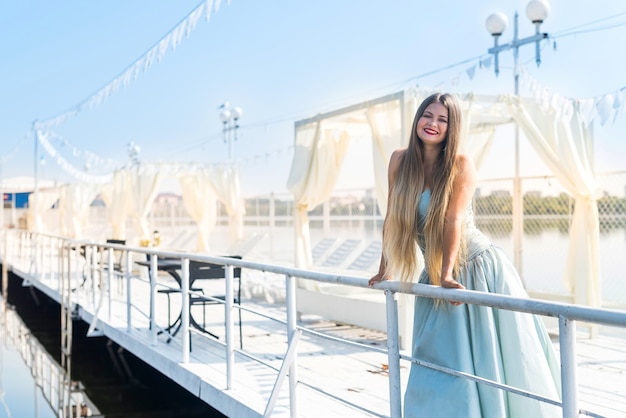 Linda garota de pé no cais com um lindo vestido de hortelã