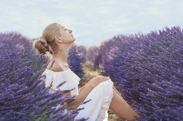 Linda garota de vestido branco em um campo de lavanda em Provence