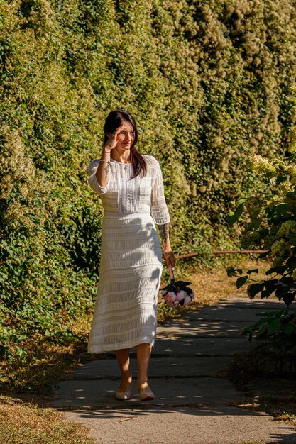 Linda garota de vestido branco no parque