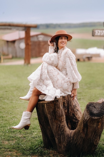Linda garota de vestido de renda vintage e chapéu no rancho