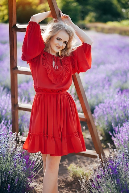 Linda garota de vestido vermelho em um campo de lavanda