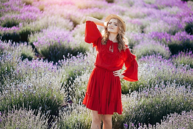 Linda garota de vestido vermelho em um campo de lavanda