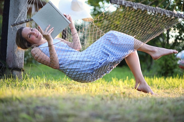 Linda garota deitada e lendo um livro no verão ao ar livre